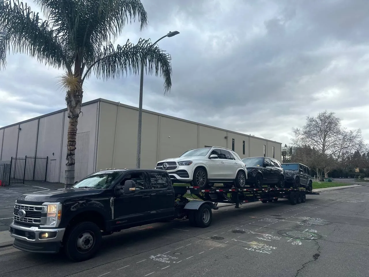 Vehicles loaded on an open car hauler trailer